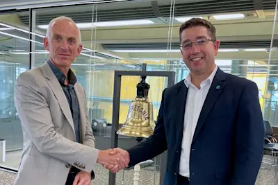 Nick Brown (CEO of Lloyd's Register) and Martin Taylor (CEO of OneOcean Group) shaking hands on the acquisition of OneOcean by Lloyd's Register.